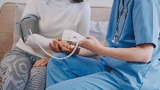 Professionnelle de santé prenant la tension au domicile